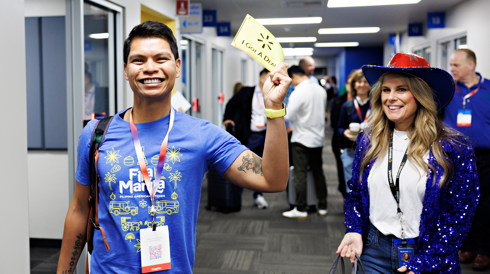 A male supplier waving his golden ticket next to a female Walmart associate in a sequin blue coat with a sequin red and blue western had. 