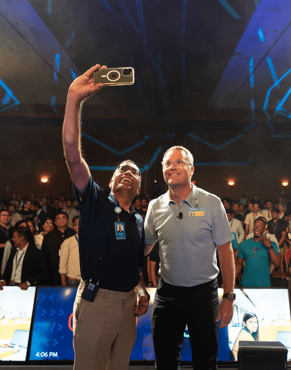 Suresh Kumar, EVP, CTO and CDO, Walmart Inc. (on the left) is shown taking a selfie with Doug McMillon, President and CEO, Walmart Inc. (on the right) with the audience in the background.