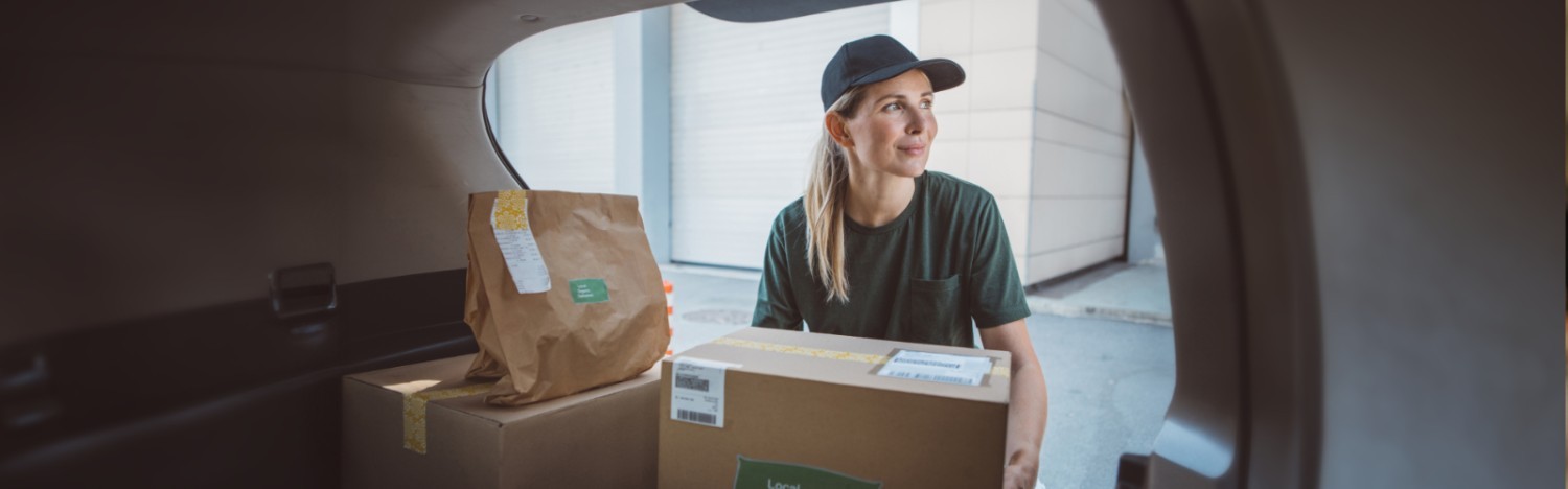delivery woman removing package from delivery van