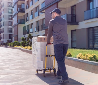 A female delivery driver in the front seat of a van typing a location into her GPS. 
