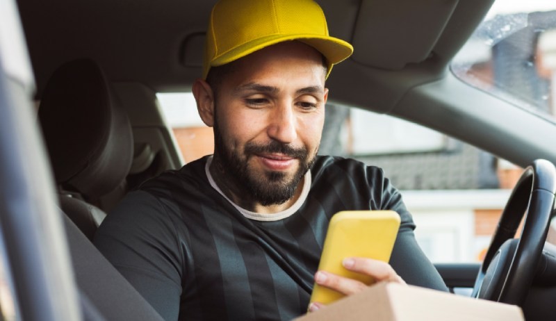 A cartoon person holding a small stack of boxes in one hand and a larger stack in the other.