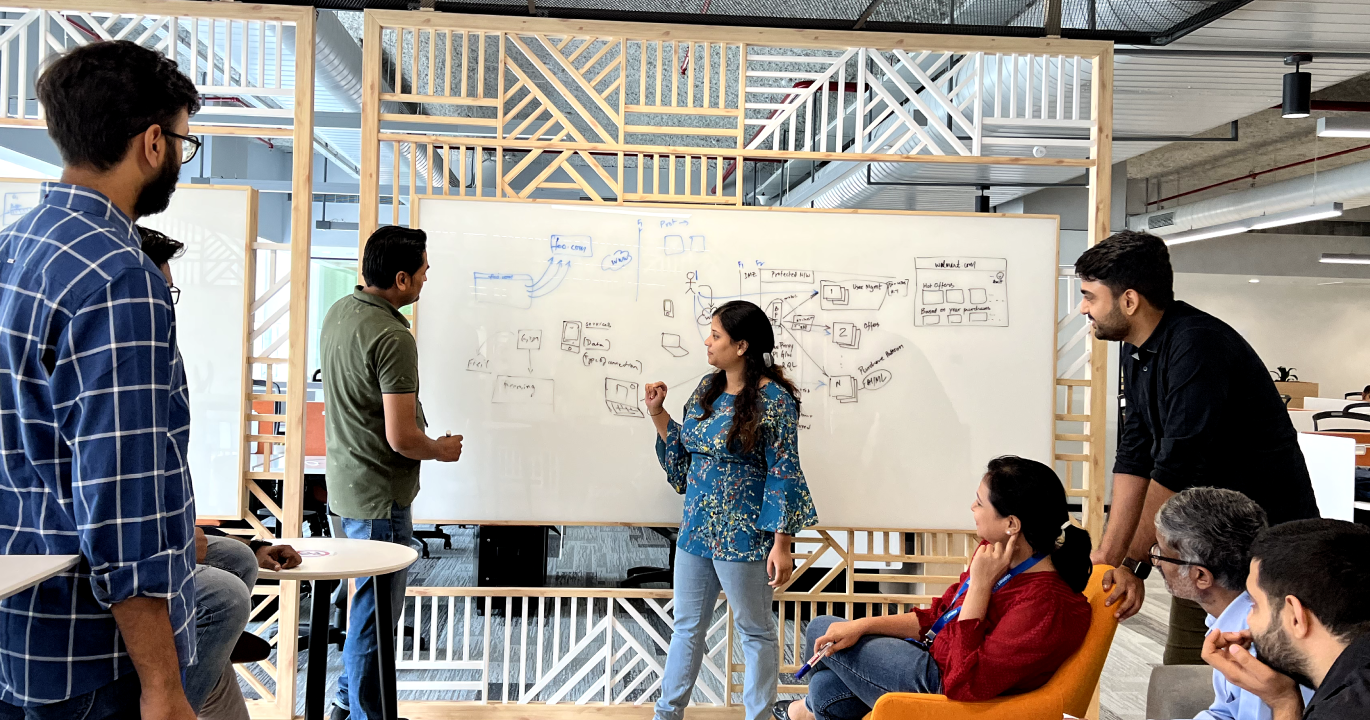 IT professionals in front of a large whiteboard at Walmart Global Tech in India