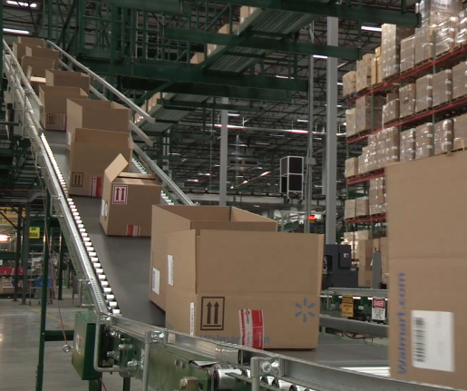 Open cargo boxes with the Walmart logo on a conveyor belt at a warehouse