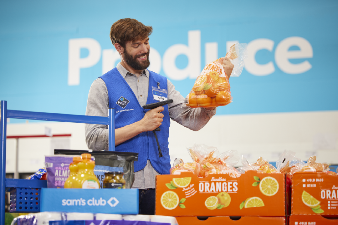 Walmart associate scanning a pack of oranges.