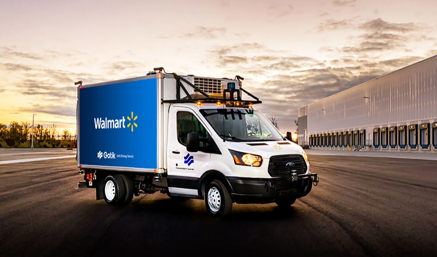 A Walmart driverless delivery truck parked at an empty parking lot