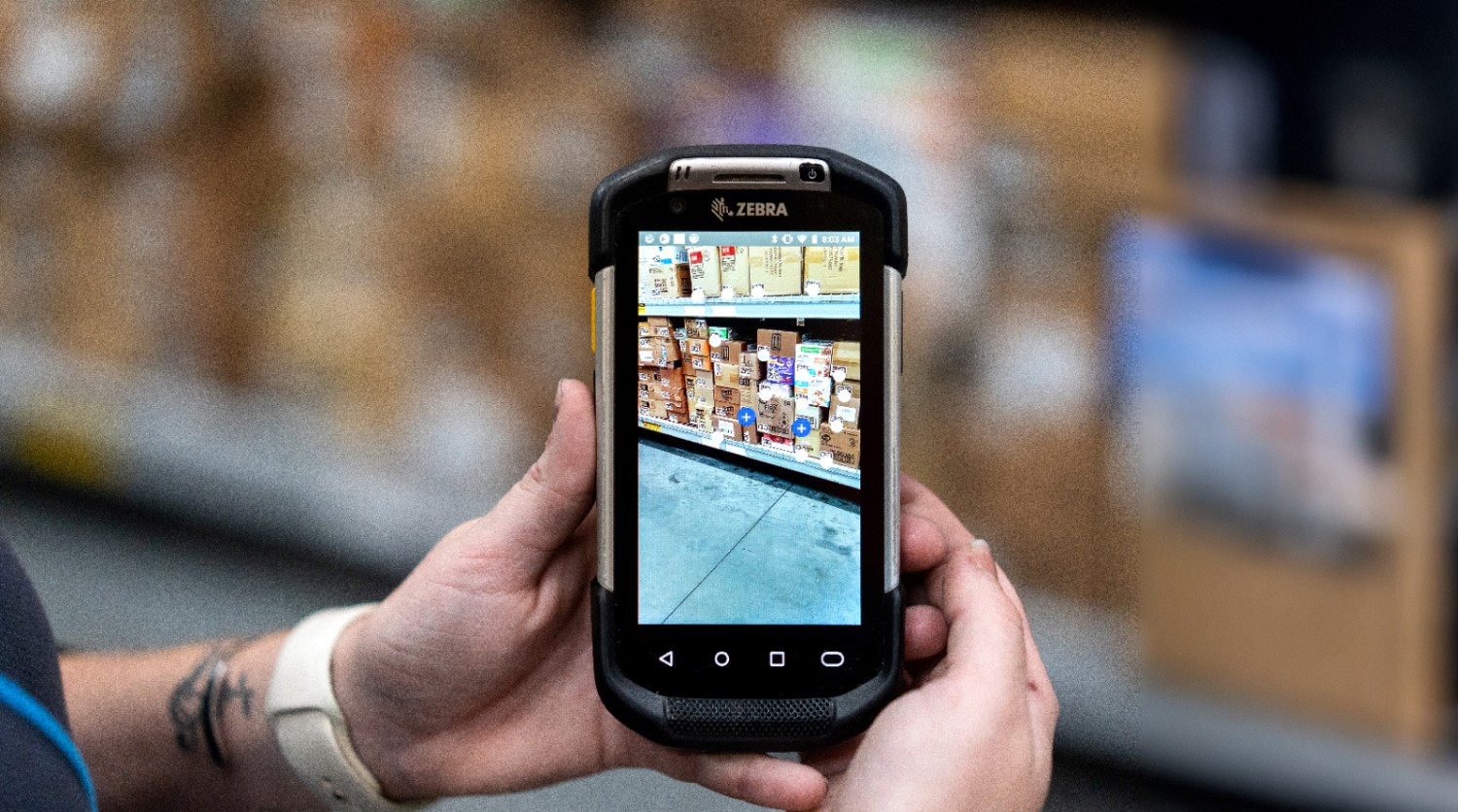 A phone screen displaying Walmart's augmented reality (AR) feature, which maps and tracks boxes in a backroom.