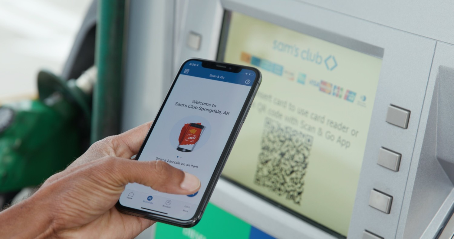 The image shows a woman using Scan & Go app to scan the barcode of a product on her phone inside a Sam’s Club